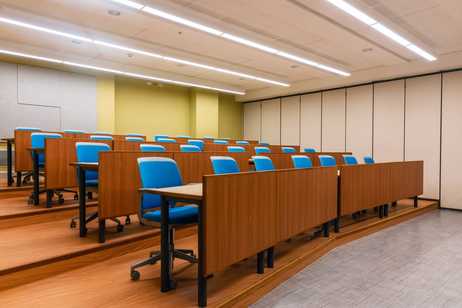 A tiered lecture room with blue seating